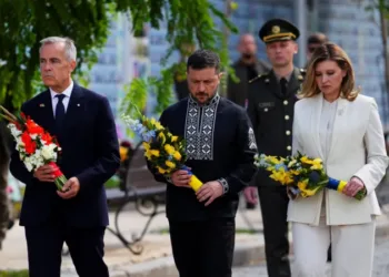 Canada's Prime Minister Mark Carney joins Ukrainian President Volodymyr Zelensky and his wife, Olena Zelenska, as they lay wreaths at the memorial wall in Kyiv