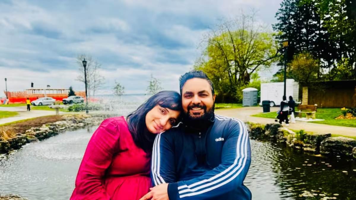a man and woman sitting next to a pond