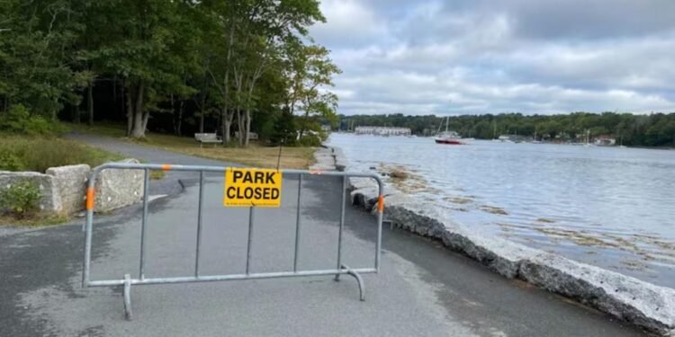 നോവ സ്കോഷ്യക്ക് ആശ്വാസം; വനപ്രവേശന വിലക്ക് ഭാഗികമായി പിൻവലിച്ചു 1 a metal fence with a yellow sign on it