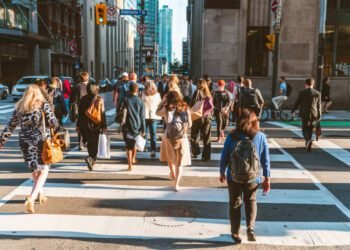 Crowd of unrecognisable people crossing street on traffic light