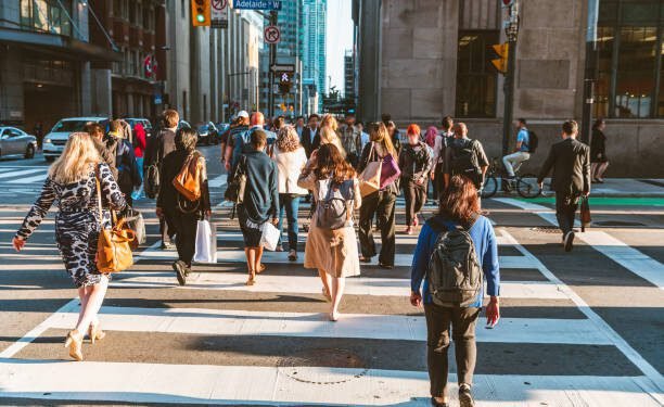 Crowd of unrecognisable people crossing street on traffic light