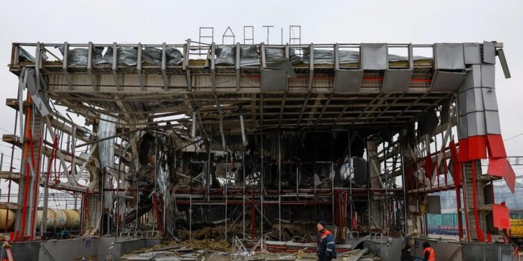 A railway employee walks in front of a railway station building