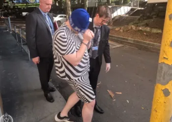 A man is escorted by police after being arrested