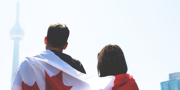 കാനഡ സ്പൗസൽ വിസ: നാട്ടിലിരുന്ന് പങ്കാളിയെ സ്പോൺസർ ചെയ്യാൻ കഴിയുമോ? പൗരന്മാർക്കും PR-കാർക്കും വ്യത്യസ്ത നിയമങ്ങൾ! 1 couple with canadian flag