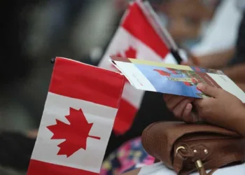 People hold Canadian flags at an citizenship ceremony in Toronto