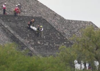 Forensic workers carry the body of a victim down a pyramid after authorities said a gunman opened fire