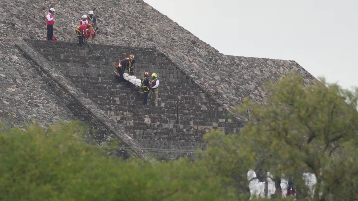 Forensic workers carry the body of a victim down a pyramid after authorities said a gunman opened fire