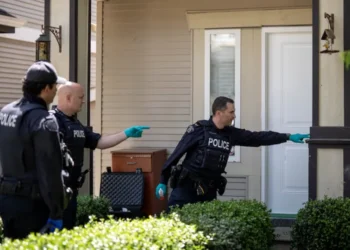 Officers investigate the scene of an alleged extortion-related shooting in Surrey