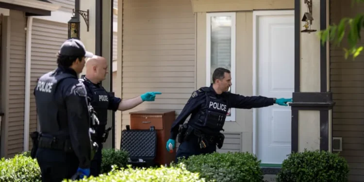 Officers investigate the scene of an alleged extortion-related shooting in Surrey