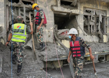 Rescuers inspect a residential building damaged in the aftermath of the flash floods in Nepal's Nuwakot district,