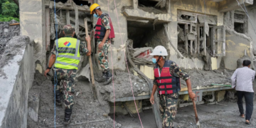 Rescuers inspect a residential building damaged in the aftermath of the flash floods in Nepal's Nuwakot district,