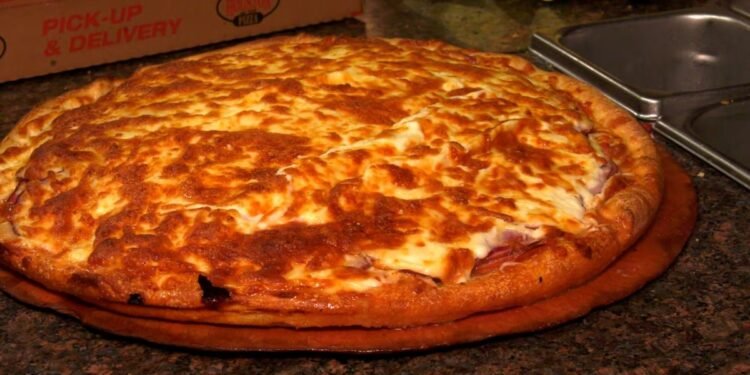 A Houston Pizza employee prepares a Regina-style pizza. (Allison Bamford/CTV News)
