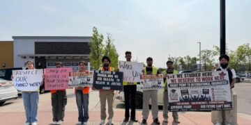 Gurpreet Singh, left, stands at a protest in Calgary, in an undated handout photo, opposing the federal immigration department's refusal of post-graduation work permits that were previously expected. Singh is among the 10 students later given an exclusion order to leave Canada.THE CANADIAN PRESS/Handout - Gurpreet Singh (Mandatory Credit)