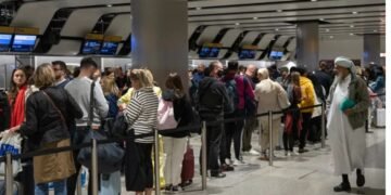 Travellers wait in a long queue to pass through the security check at Heathrow in London, England
